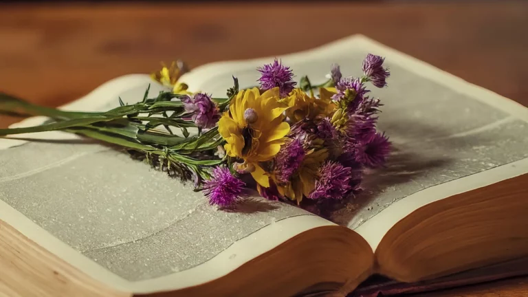 Un ramo de flores silvestres sobre un libro abierto con un marcador de madera.